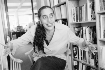 Guinier posing in front of a shelf of books